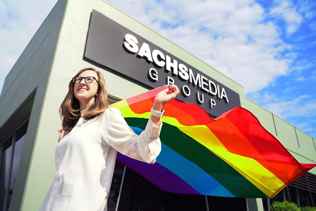 Allison P. Couch, author and Sachs Media Group employee celebrates Pride Month with LGBTQ pride flag